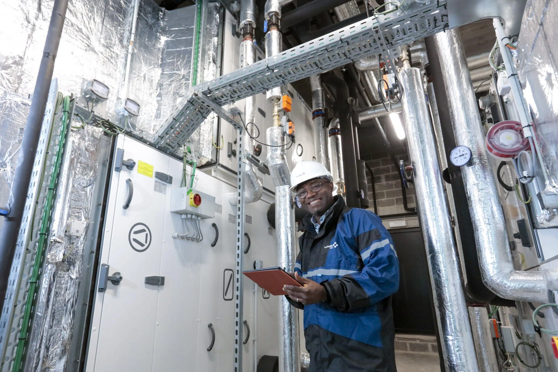 Technician documenting equipment conditions in a commercial mechanical room